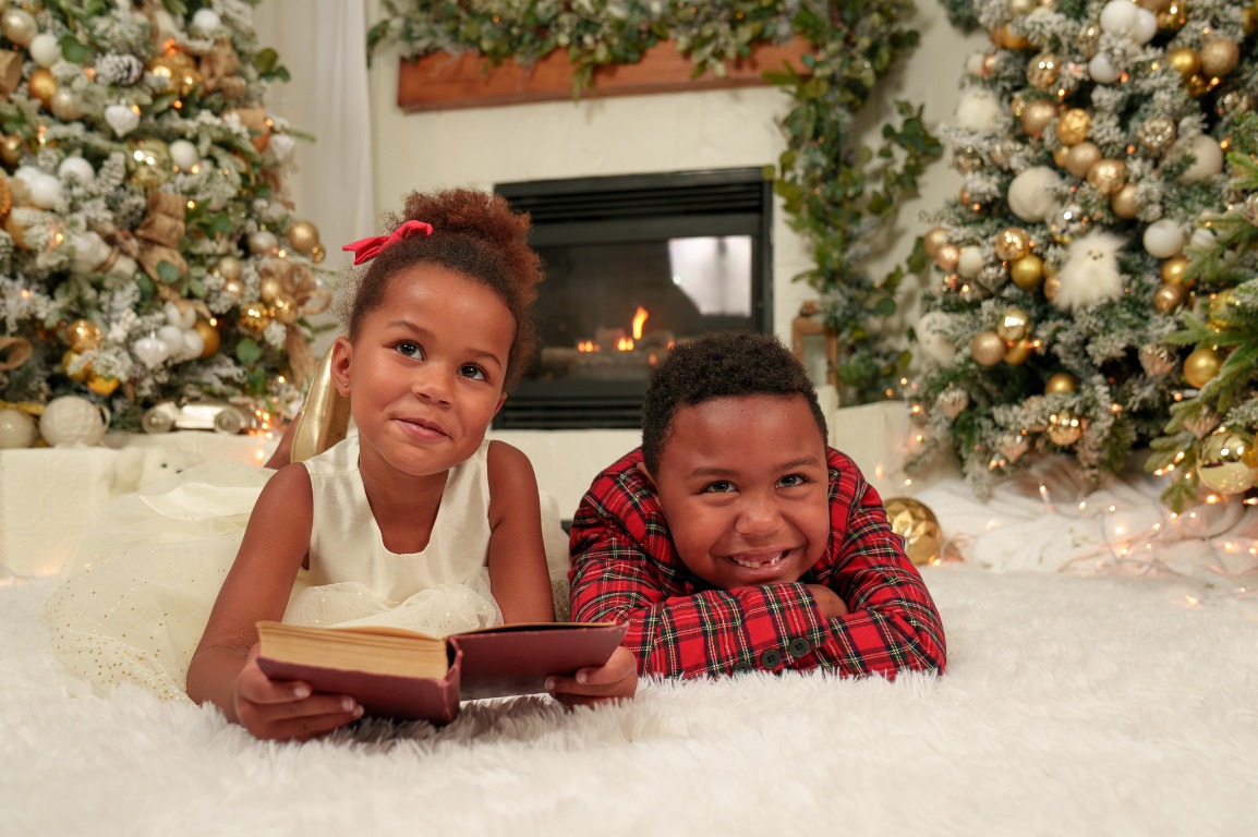 Two children sharing a Christmas storybook portrait