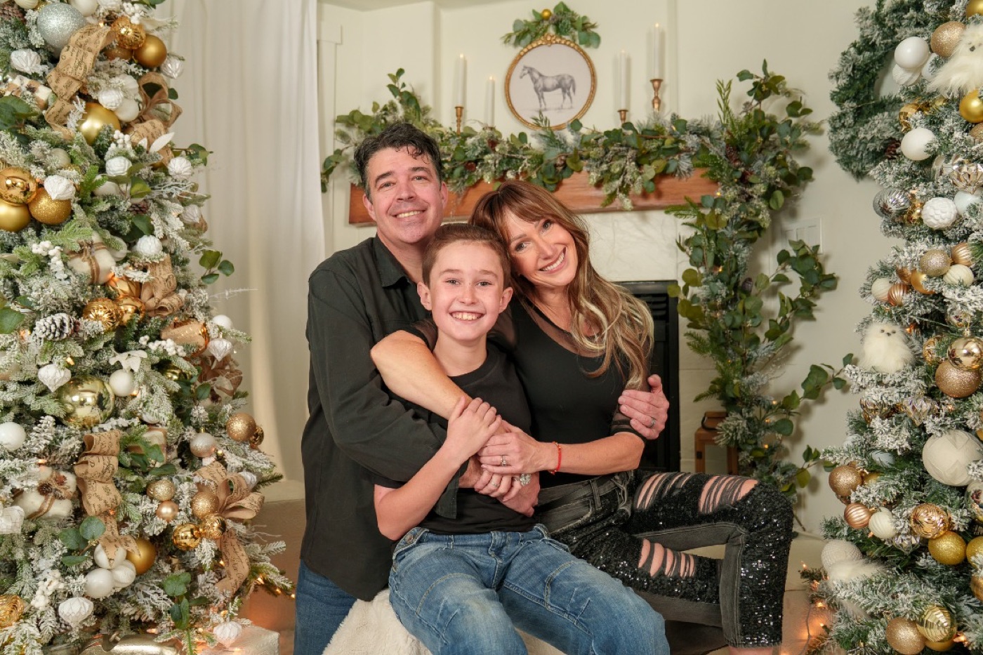 Parents and their son sharing a Christmas portrait by the fireplace